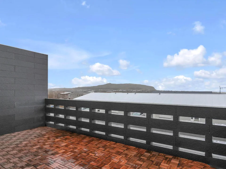 Roof terrace wall and balustrade clad in dark self-coloured textured fibre cement boards