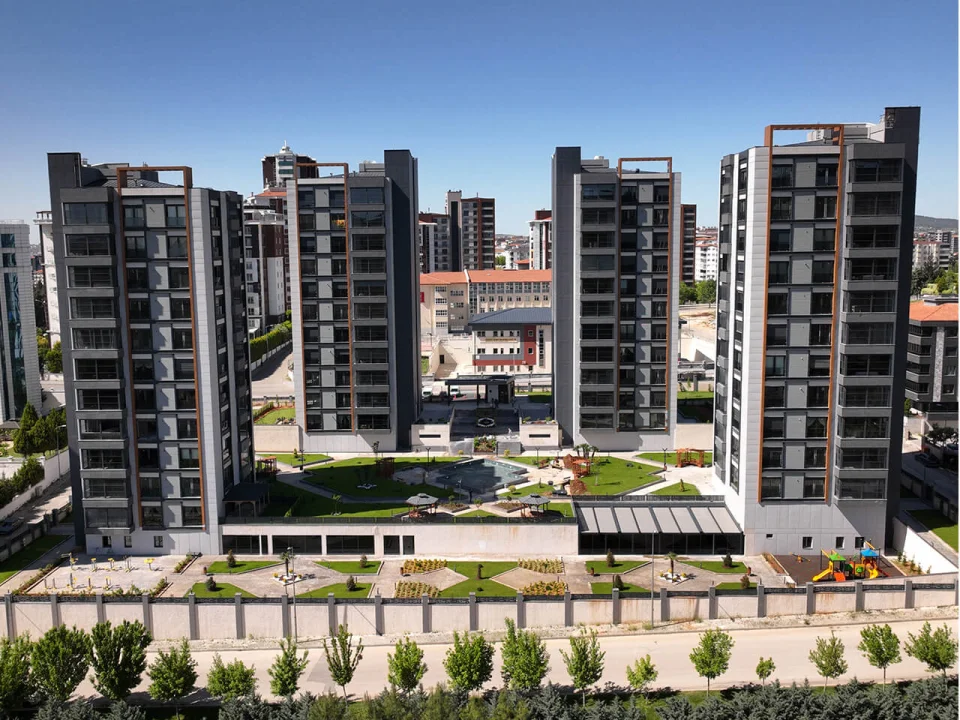Multi-tower modern residential complex with landscaped courtyard clad in grey and white grooved and smooth fibre cement panels