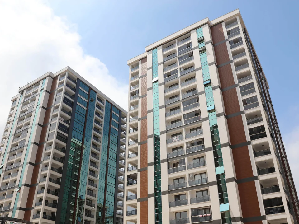 Twin high-rise residential towers clad in off-white, anthracite and terracotta painted smooth fibre cement facade boards