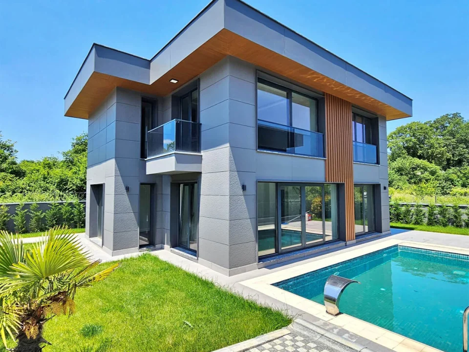 Luxury contemporary two-storey villa with pool featuring slate-grey textured fibre cement wall panels and warm wood-look roof soffit