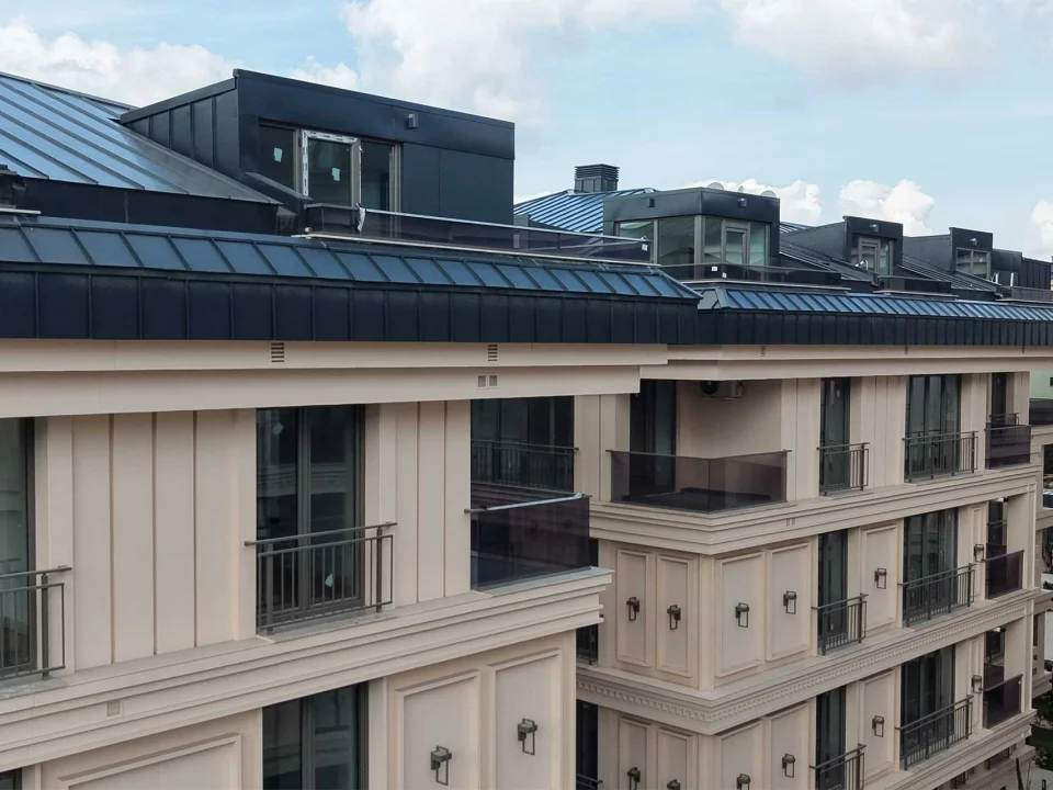 Classic contemporary residential blocks clad in warm beige stone-textured fibre cement panels, recessed window frames and dark mansard roofs