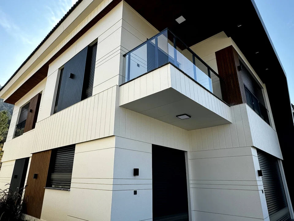 Modern two-storey detached villa clad in off-white vertical striped fibre cement panels with cantilevered glass balcony and dark window shutters